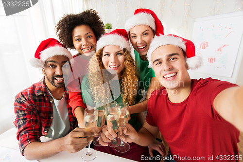 Image of happy team celebrating christmas at office party