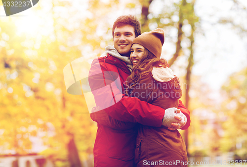 Image of happy young couple hugging in autumn park