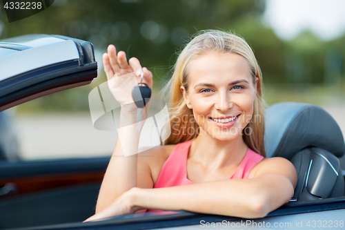 Image of happy young woman with convertible car key