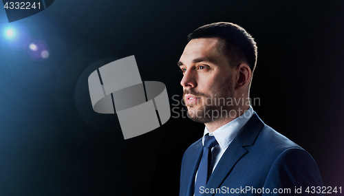 Image of businessman in suit over black