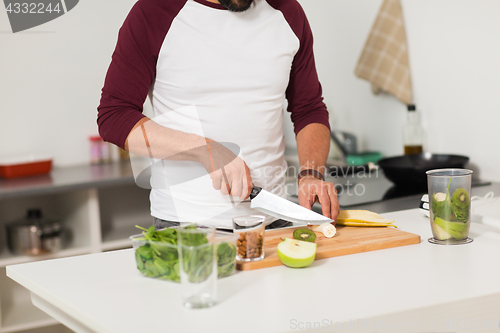 Image of man with blender and fruit cooking at home kitchen