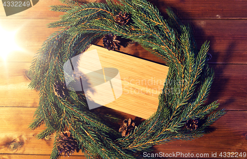 Image of natural green fir branch wreath and wooden board