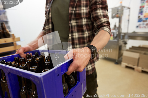 Image of man with bottles in box at craft beer brewery