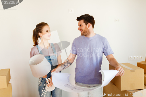 Image of couple with boxes and blueprint moving to new home