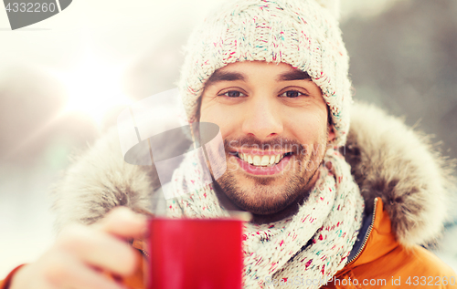 Image of happy man with tea cup outdoors in winter