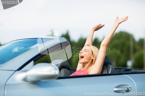 Image of happy young woman in convertible car