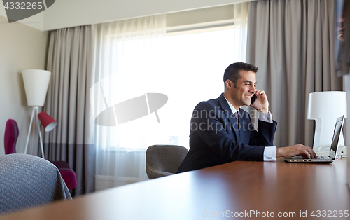 Image of businessman with laptop and smartphone at hotel