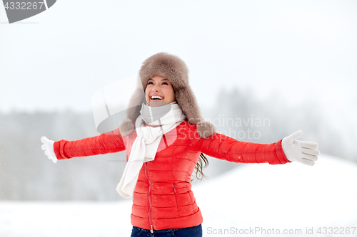 Image of happy woman in winter fur hat outdoors