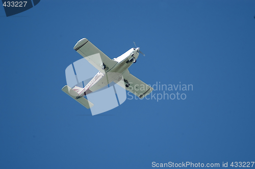 Image of Small airplane over blue sky