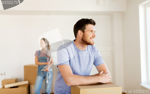 Image of happy couple with boxes moving to new home