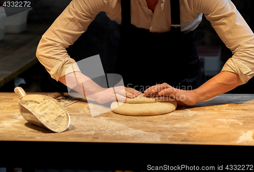 Image of baker making bread dough at bakery kitchen