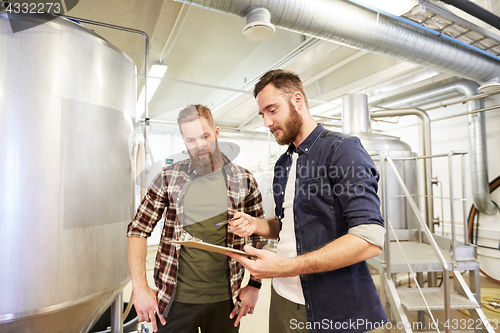 Image of men with clipboard at brewery or beer plant