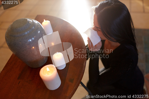 Image of woman with cremation urn at funeral in church