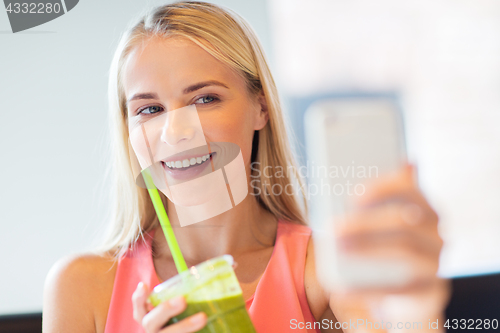 Image of woman with smartphone taking selfie at restaurant