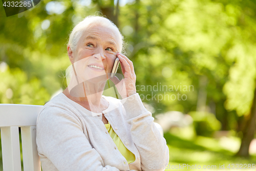 Image of happy senior woman calling on smartphone in summer