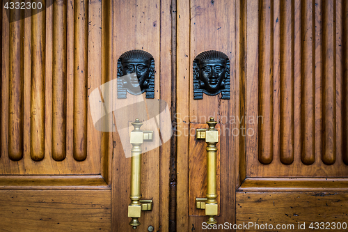 Image of Sphinx heads entrance on wooden door