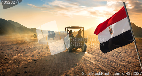 Image of Flag and buggies in desert