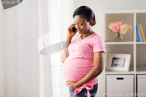 Image of happy pregnant woman calling on smartphone at home