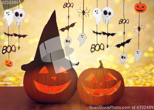 Image of carved pumpkins in witch hat and halloween garland