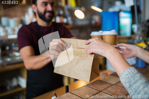 Image of man or bartender serving customer at coffee shop