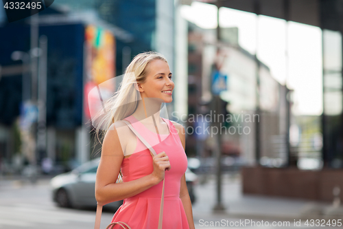 Image of happy smiling young woman on city street