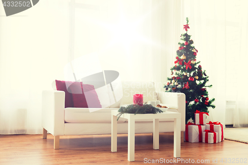 Image of sofa, table and christmas tree with gifts at home