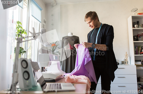 Image of fashion designer with cloth making dress at studio