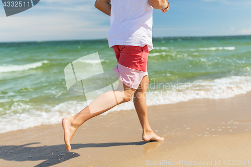 Image of happy man running along summer beach