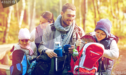 Image of happy family with backpacks and thermos at camp