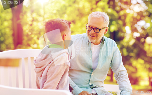 Image of grandfather and grandson talking at summer park