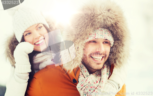 Image of happy couple having fun over winter background