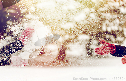 Image of happy friends playing with snow in winter