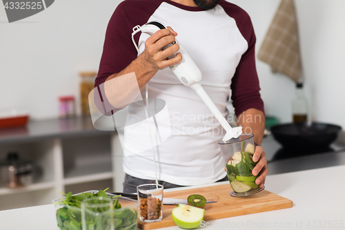 Image of man with blender and fruit cooking at home kitchen