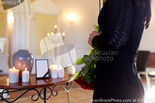 Image of woman with cremation urn at funeral in church