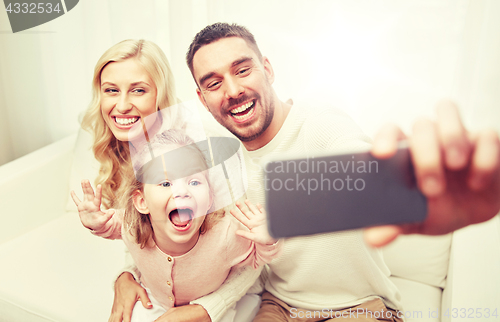 Image of family taking selfie with smartphone at home