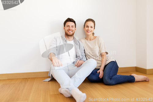 Image of happy couple at empty room of new home