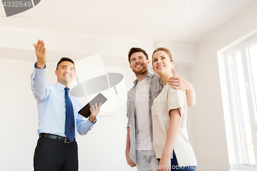 Image of couple and realtor with tablet pc at new home