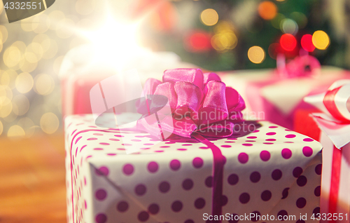 Image of close up of gift boxes over christmas tree lights