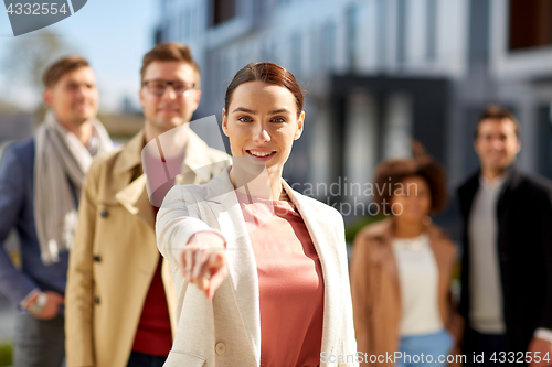 Image of happy smiling woman pointing finger at you 