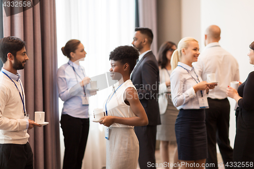 Image of business people with conference badges and coffee