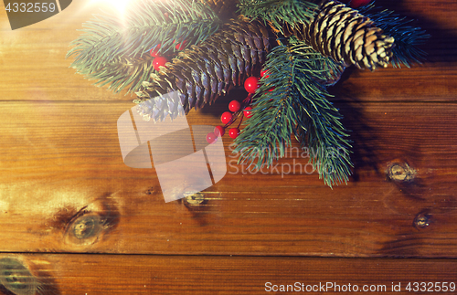 Image of close up of fir branch with cones on wooden table