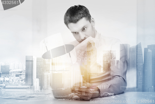 Image of stressed businessman with tablet pc and documents