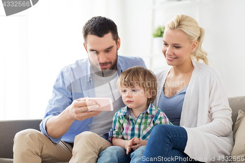 Image of happy family with smartphone at home