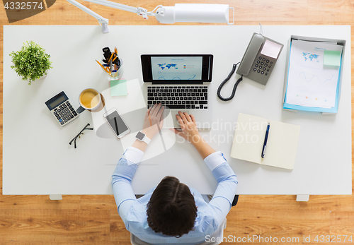 Image of businesswoman working on laptop at office