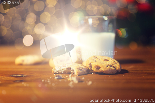 Image of close up of cookies and milk over christmas lights