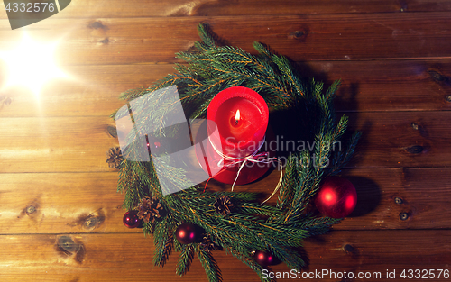 Image of fir branch wreath with candle on wooden table