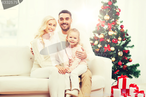 Image of happy family at home with christmas tree