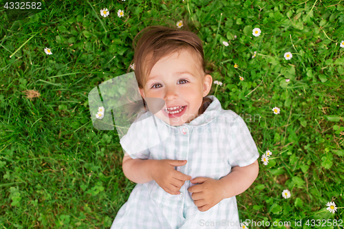 Image of happy baby girl on green summer field