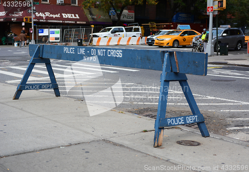 Image of Police line do not cross wooden barrier on a sidewalk