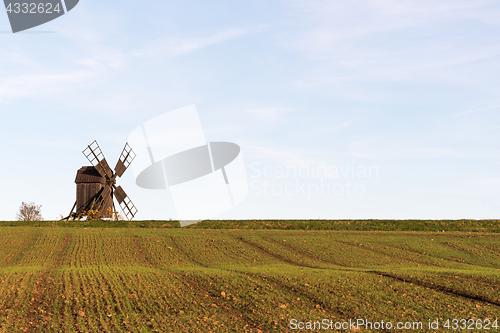 Image of Old windmill by a farmers corn field